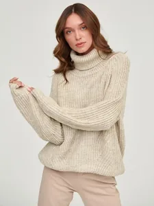 Detailed view of women's chunky knit turtleneck sweater in beige with a relaxed fit