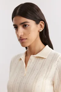 Close-up of ivory polo collar knit sweater with delicate pointelle hollow pattern