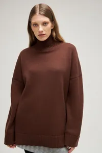 Detailed view of a loose dark brown turtleneck knit sweater for women's autumn winter fashion.