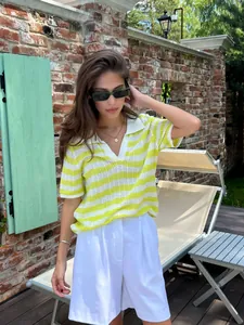 Outdoor shot of a yellow and white striped knit polo shirt with breathable texture