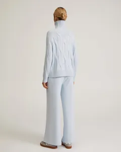 Back view of woman in light blue turtleneck cable knit sweater and wide-leg pants set