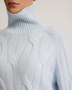 Close-up detail of a light blue cable knit turtleneck sweater showing soft texture