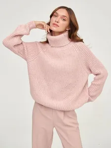Close-up of a stylish pink turtleneck chunky knit sweater with visible ribbed texture for winter