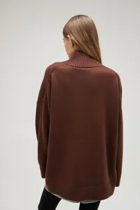 Back view of a cozy brown women's oversized turtleneck sweater in fine knit fabric