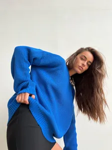 Detail view of a vibrant blue chunky knit sweater featuring a relaxed round neck fit