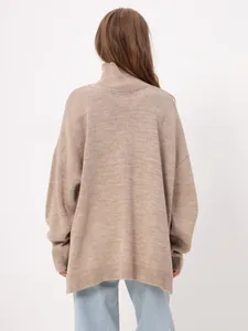 Detailed rear view of oversized beige turtleneck knit sweater showing drop shoulder style