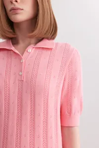 Close-up detail of a pink short sleeve knit polo sweater with delicate openwork texture