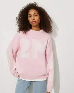 Detailansicht des rosa Oversized-Strickpullovers mit einer großen weißen 21-Grafik