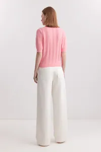 Back view of a stylish pink short sleeve knit polo sweater with pointelle texture.