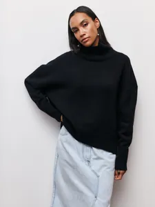 Mannequin portant un pull noir oversize à col roulé associé à une jupe en jean clair