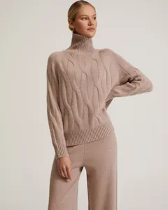 Close-up detail of a beige cable-knit turtleneck sweater and matching wide-leg lounge pants set