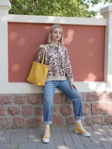 Outdoor street style view of a woman in a leopard print semi-high neck knit sweater