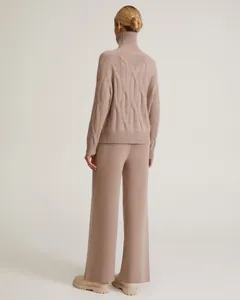 Back detail showing the cable-knit texture of the beige turtleneck and wide-leg set.