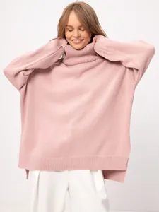 Model wearing a cozy pink oversized turtleneck knit sweater with a loose fit.