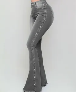 Detail van grijze flared jeans met hoge taille, zijrivetten en een rafelige zoom.