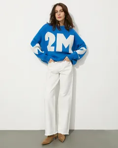 Detailansicht eines blauen Oversize-Strickpullovers mit einem weißen 2M-Schriftzug