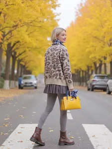 Woman in a leopard print mock neck knit sweater on a scenic autumn street view.