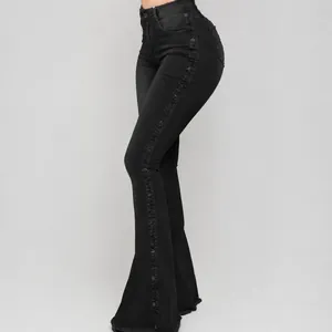 Zijaanzicht detail van zwarte flare jeans met hoge taille en knopen