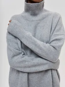 Gros plan sur le col roulé côtelé et la texture douce en tricot d'un pull gris femme