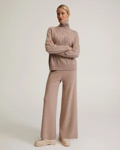 Full body view of model in a cozy loose high-neck cable knit sweater and wide-leg pants set.