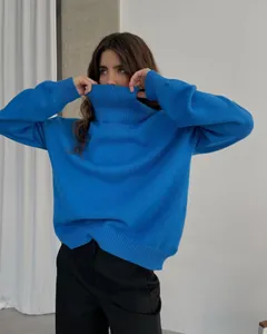 Detail of oversized blue turtleneck knit sweater with thick ribbed collar and cuffs