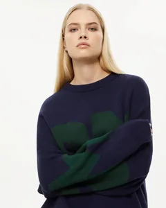 Nahaufnahme eines marineblauen Oversized-Strickpullovers mit grünem Muster