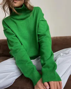 Close-up of vibrant green turtleneck knit sweater showing texture and loose fit