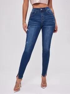 Detailansicht des geschlitzten Saums mit Perlenbesatz an High-Waist-Slim-Jeans