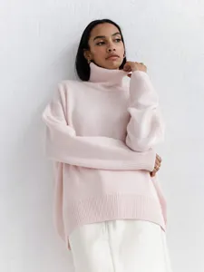 Gros plan d'un pull à col roulé rose oversize en maille avec détails côtelés et texture