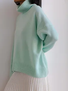 Detailed close-up view of a mint green thick knit turtleneck sweater with ribbed collar