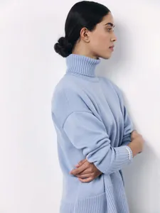 Profile view of a light blue turtleneck sweater with loose knit design for women
