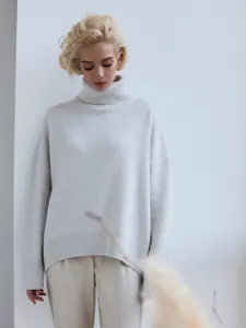 Model wearing an elegant light gray oversized high-neck thick knitted sweater for winter.