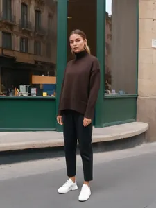 Mannequin portant un pull à col roulé marron foncé surdimensionné dans une rue urbaine