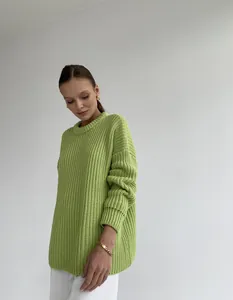 Detail view of a stylish lime green chunky knit crewneck sweater for women in autumn