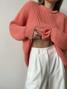 Detailed view of women's chunky coral knit sweater with ribbed crew neck and loose fit style