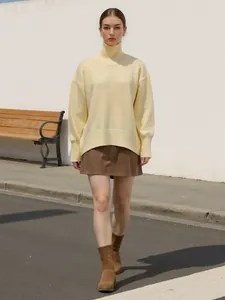 Photo lifestyle d'un mannequin portant un pull à col roulé jaune pâle ample en extérieur.