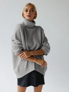 Detail view of a loose grey oversized turtleneck sweater with a cozy thick knit texture