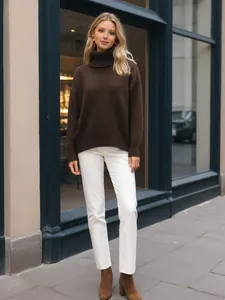 Woman wearing an elegant brown turtleneck sweater and white trousers in urban street