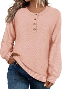 Gros plan sur la maille gaufrée et les boutons d'un pull rose pour femme en détail