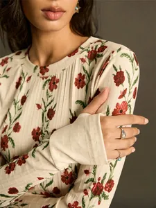 Detail of a slim-fit knit top with vintage red floral print and ribbed texture.