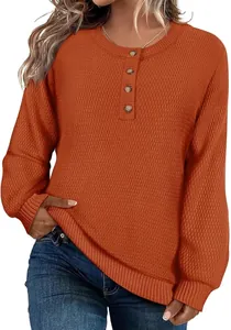 Gros plan détaillé du pull en maille orange pour femme avec boutons et col rond