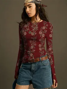 Lifestyle detail of vintage floral print long sleeve top worn by model with denim shorts.