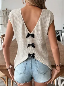 Close-up of white waffle knit top with deep V-back and three black ribbon bows.