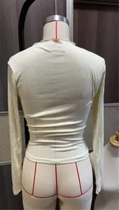 Detalle de la vista trasera de una camiseta ajustada de manga larga color crema en maniquí