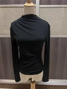 Detalle de la camiseta negra de manga larga ajustada con un elegante diseño fruncido