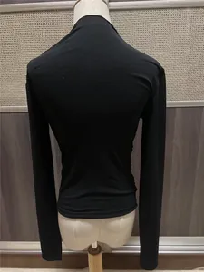 Vista posterior de una camiseta negra de manga larga ajustada con fruncidos.