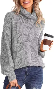 Gros plan détaillé montrant le motif de maille torsadée d'un pull à col roulé gris pour femmes.