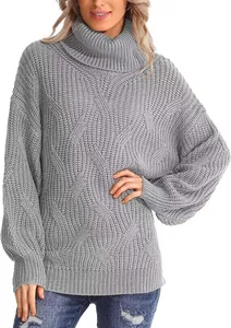 Vue détaillée d'un pull gris tendance à col roulé oversize avec une maille torsadée.