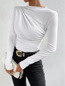 Detalle de top blanco de manga larga ajustado con un elegante diseño de pliegues