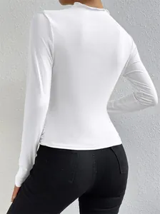 Vista posterior de una camiseta blanca de manga larga ajustada con detalles fruncidos laterales